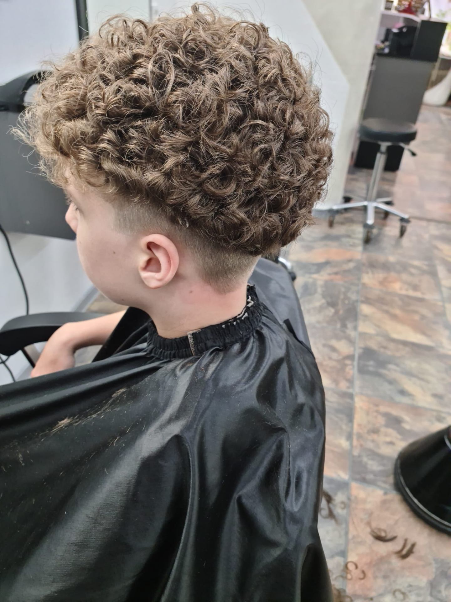 Dauerwelle mit definierten Locken und Fade an den Seiten